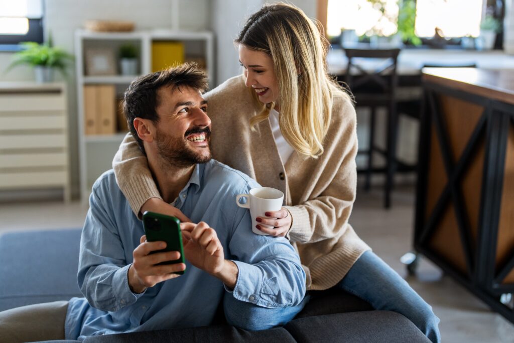 A supportive couple discussing residential inpatient treatment options in a comfortable living room.